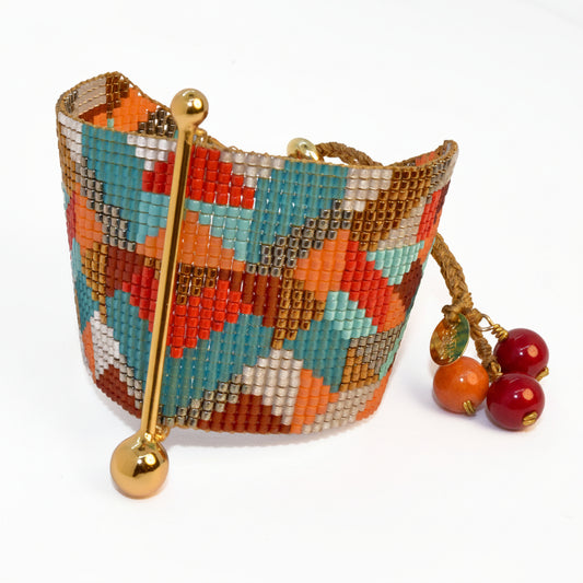 Colorful beaded clutch with a gold handle and matching earrings on a white background