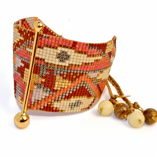 Beaded bracelet with geometric pattern and gold accents on a white background