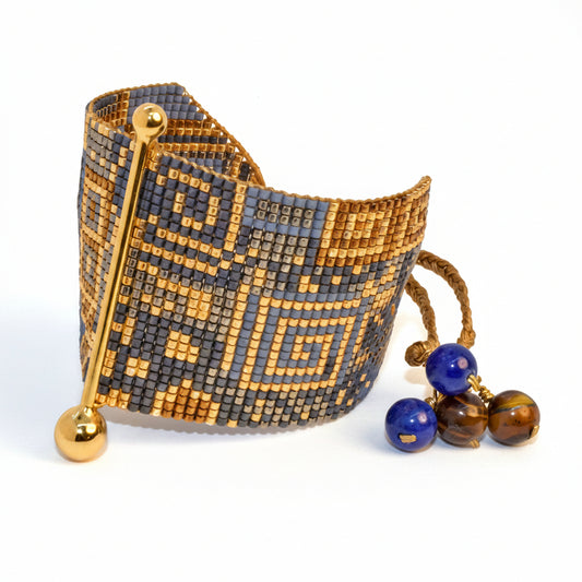 Beaded bracelet with geometric pattern and three beads on a light gray background